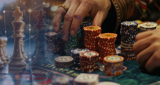 Man's hands holding poker chips to make a wager.